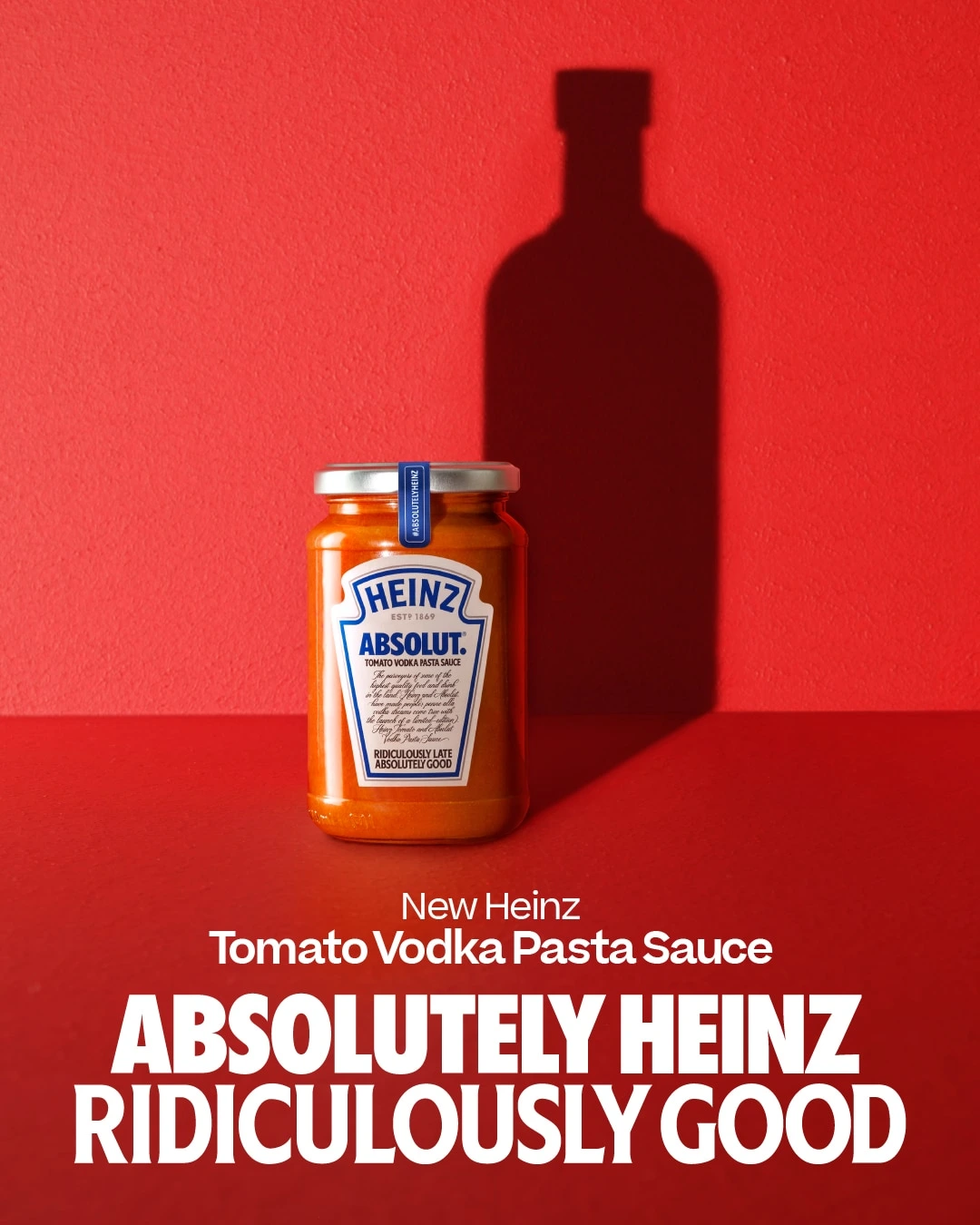 Frasco de salsa Heinz x Absolut sobre fondo rojo con eslogan Absolutely Heinz